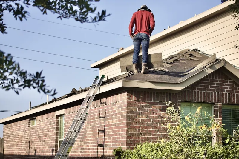 Professional roofer working on a residential roof in Normal
